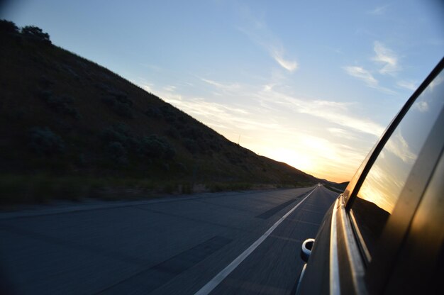 Car moving on road against sky