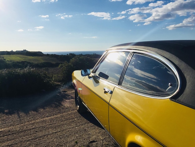 写真 空の向こうの野原の中の道路に乗った車