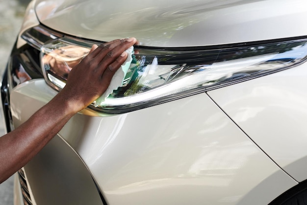 Car Owner Wiping Oxidized Headlights