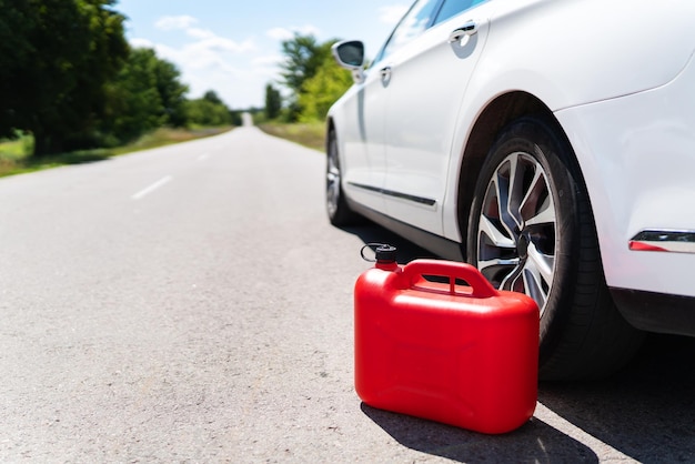 길가에 주차된 자동차 빈 빨간색 용기 운전자가 길에 있습니다. 길에서 도와주세요 연료 부족 기름 디젤 휘발유