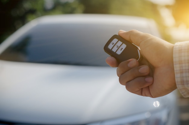 Photo car remote control by smart key, hand holding smart key to lock doors of white car