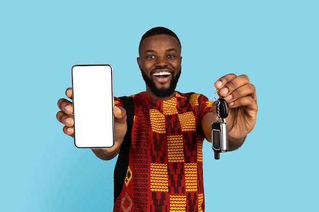 キーと空白のスマートフォンを示す陽気な黒人男性のレンタカーアプリ