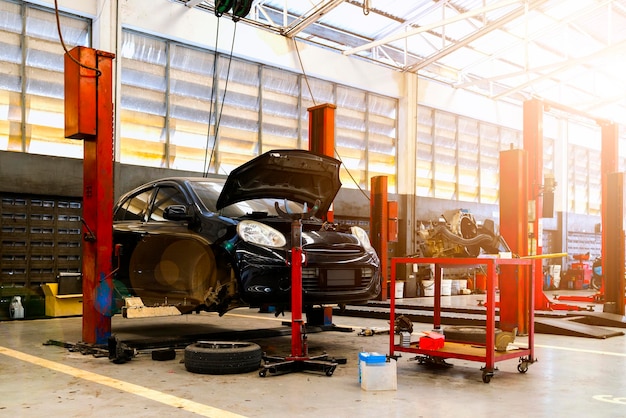 Car repair in garage service station with softfocus and over light in the background