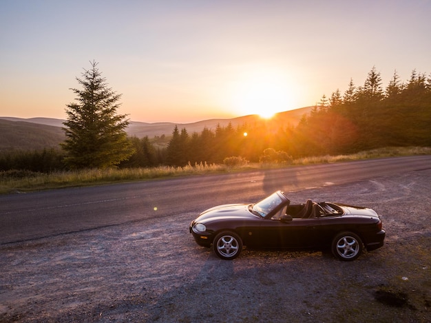 Photo car on road against sky during sunset