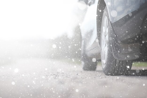 A car on rural road in the first autumn snow. The first winter snow on the country road, the car under the snow.