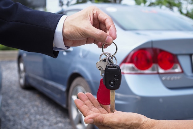 The car salesman and the key to the new owner.   