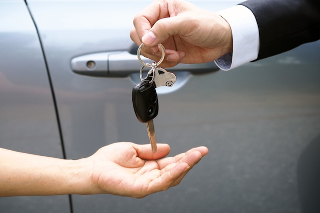 The car salesman and the key to the new owner.   