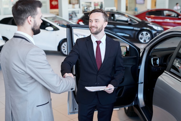 Car Salesman Shaking Hands with Client