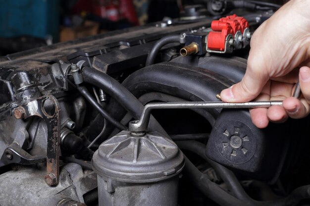 Car service Engine repair mechanic hand with wrench fuel filter