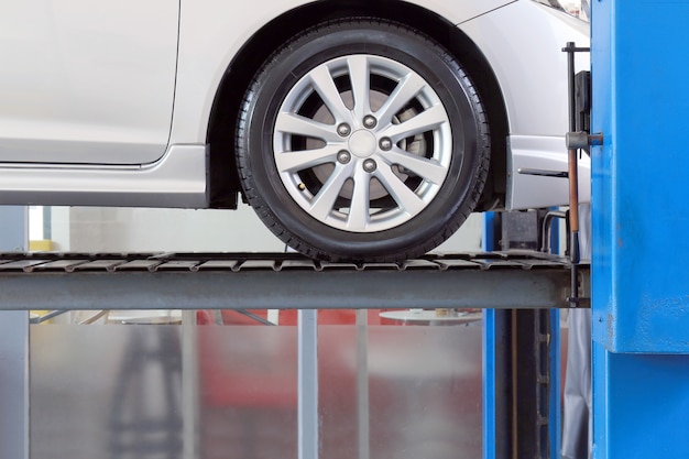 Photo car on service garage with mechanical tools for car under repair, auto mechanic working in car service centre