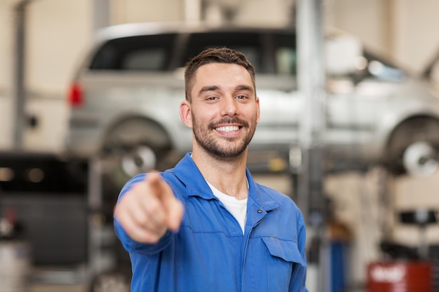 car service, repair, maintenance and people concept - happy smiling auto mechanic man or smith at workshop