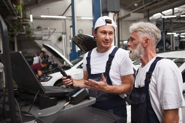 Car service repairmen doing computer diagnostics at the garage