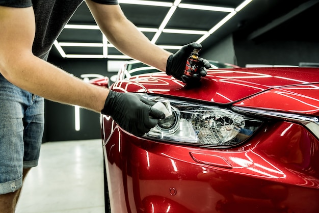 Car service worker applying nano coating on a car detail.