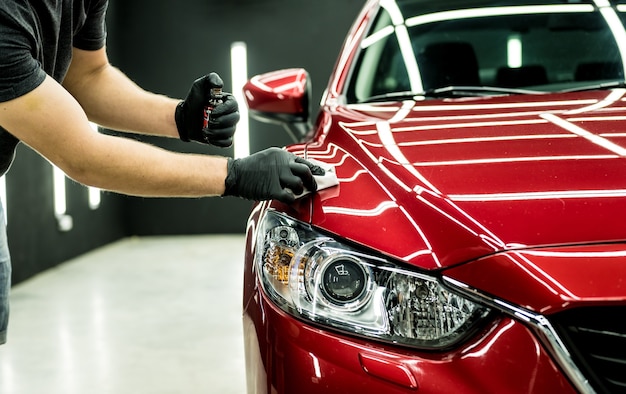 Photo car service worker applying nano coating on a car