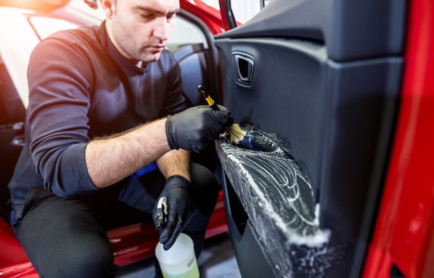 車のサービスワーカーは、特別なブラシで内部を掃除します
