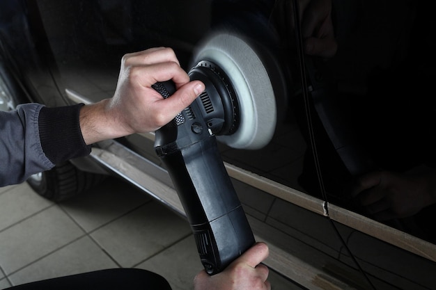 Car service Worker polishing of the car