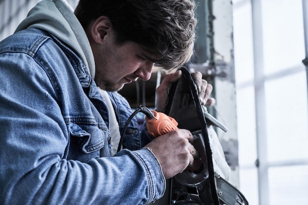 Car service worker repairs restores car