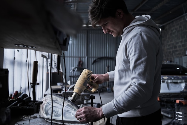 Car service worker repairs restores car