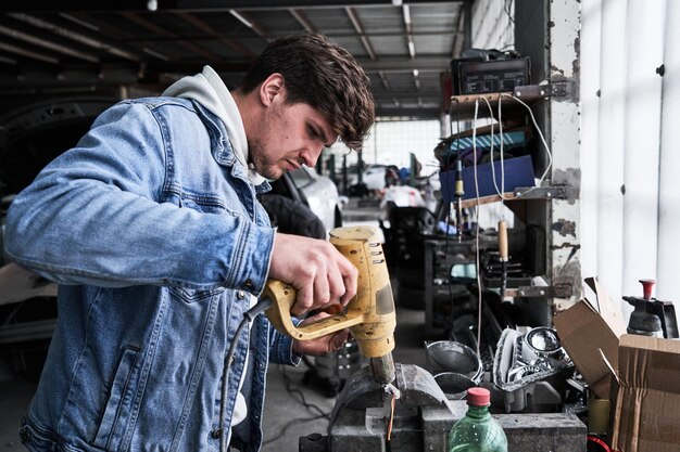 Car service worker repairs restores car