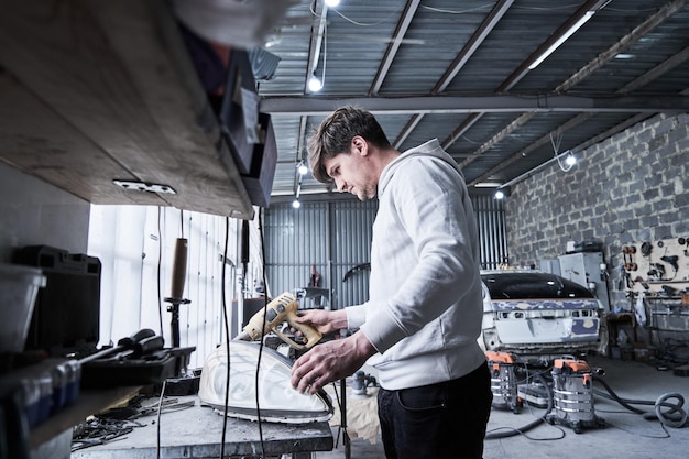 Car service worker repairs restores car