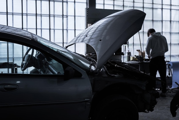 Car service worker repairs restores car