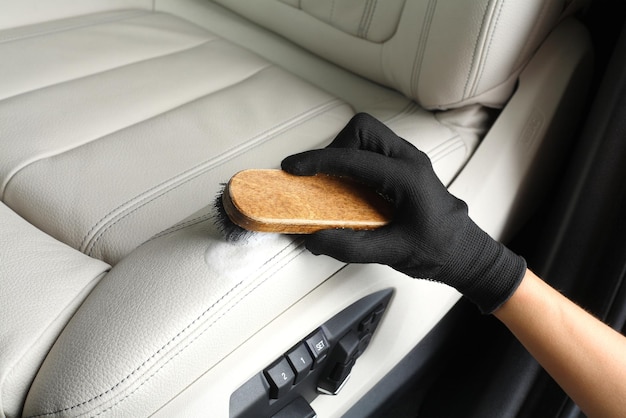 Car service Worker washing of interior by a brush