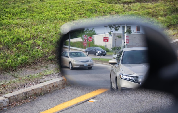 車のサイドミラーは、反射による安全性の意識とドライバーの視野の視覚的拡張を表します。