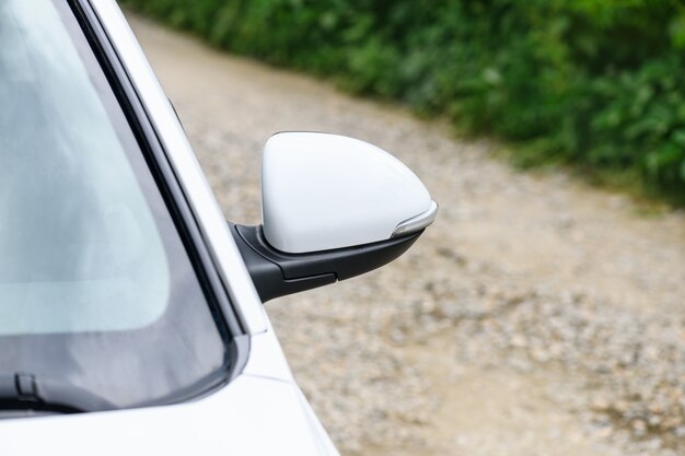 Car side mirror, road side view. Transportation background