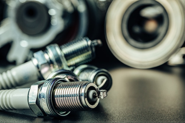 Car spark plugs on dark blurred background