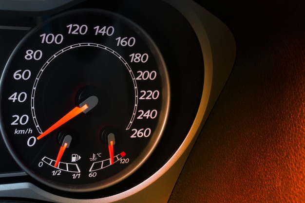 Car speedometer dial with red backlit close-up