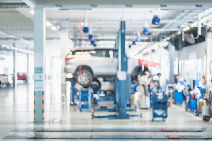Photo ショップ、ガレージ、またはサービスステーションで車を修復する自動車技術者
