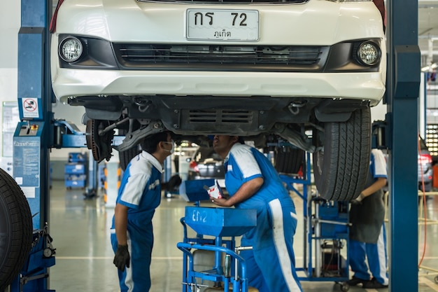 Foto tecnico di automobile che ripara automobile in officina