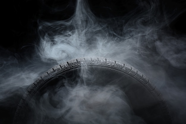 Фото Автомобильная шина покрыта каплями воды в тумане