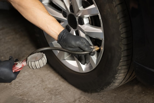 자동차의 자동차 타이어 가스 펌핑을 팽창시키는 공기압 게이지 정비공을 사용한 자동차 타이어 압력 체크