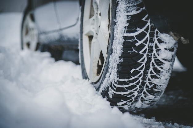 雪で覆われた道路上の冬の車のタイヤのクローズ アップ画像