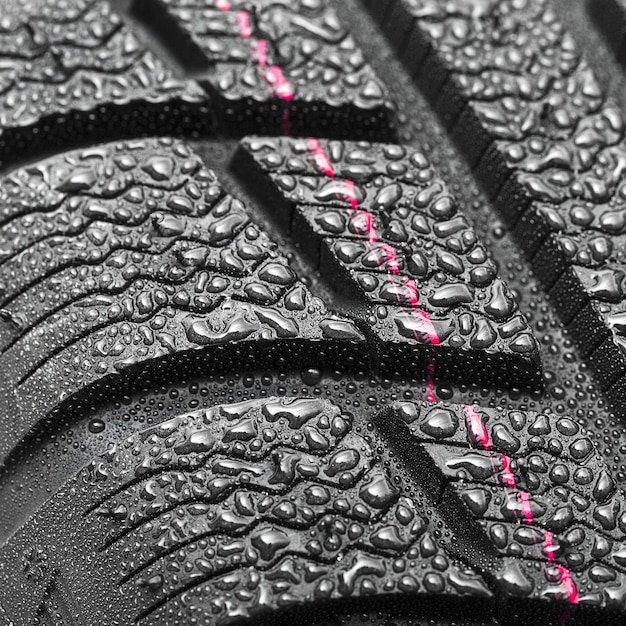 Car tires close-up Winter wheel profile structure with water drops on white background