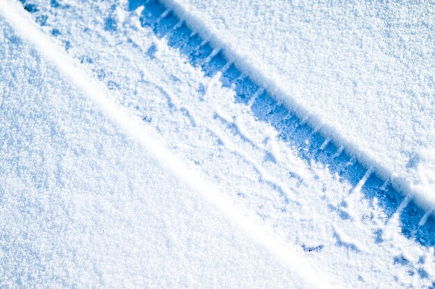 Car tires on winter road. Christmas winter background with snow  