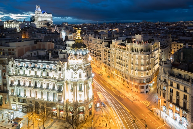 Auto e semafori sulla gran via, la principale via dello shopping a madrid di notte. spagna,