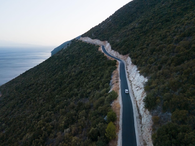 海岸の景色を望む山の中を道路で移動する車の旅のコンセプト