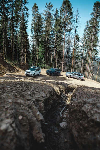 山につながる田舎道で運転する車の旅行の概念suv