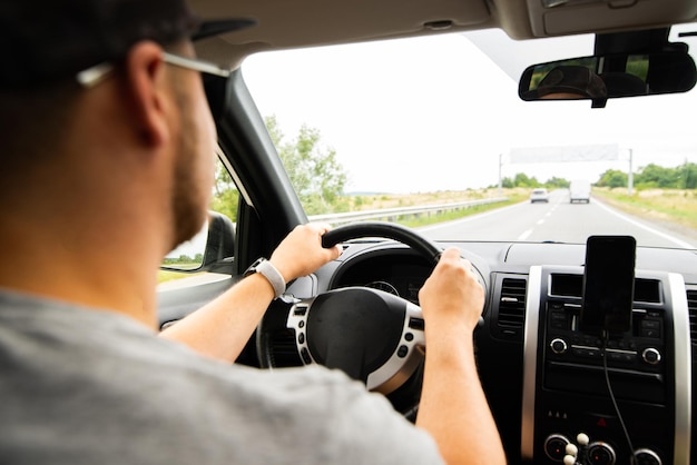 車を運転している若い白人男性の中から車の旅のコンセプトビュー