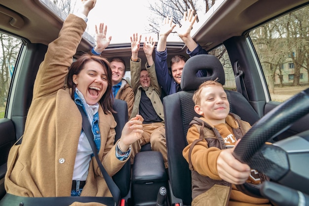 Foto concetto di divertimento di viaggio in auto ragazzino che guida l'auto con gli adulti guidatori insicuri