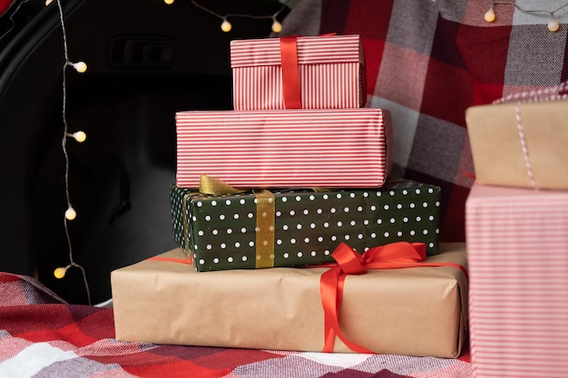 Car trunk full of gift boxes, presents and garland for Christmas holidays