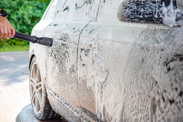 Car wash. The process of washing a car with active foam under pressure. Self-service manual car wash. Car care concept