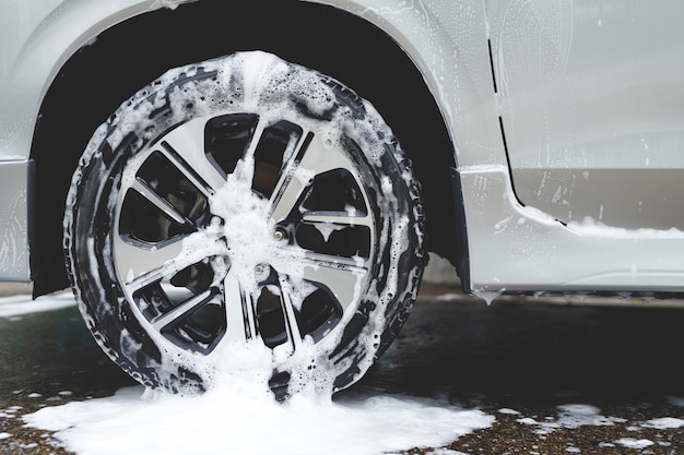 Autolavaggio con sapone a schiuma attiva. pulizia del pneumatico della ruota. concetto di servizio di pulizia commerciale.