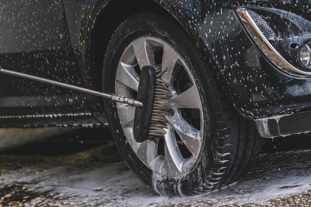 Car washing with soap and brush Wheel aloy cleaning at car wash station