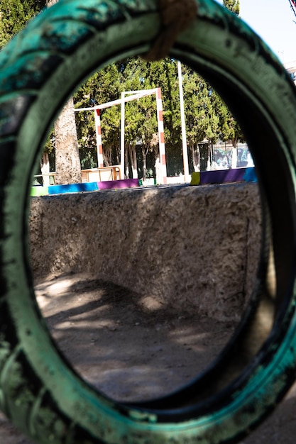 A car wheel painted and placed as a swing in a school.