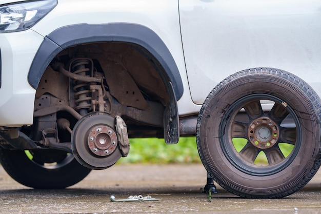 路上でタイヤを使わずに屋外で車のホイールを修理する 故障した故障後にスペアパーツを交換するための自動車のガレージ