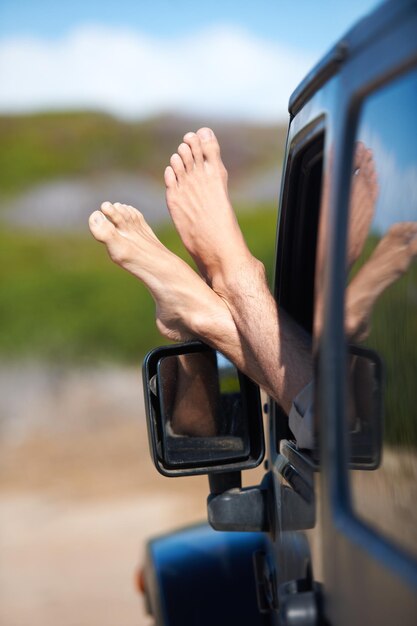 Photo car window feet and person on outdoor journey easy adventure or motor transport on travel vacation holiday or road trip automobile relax legs and foot of driver driving in suv van or vehicle