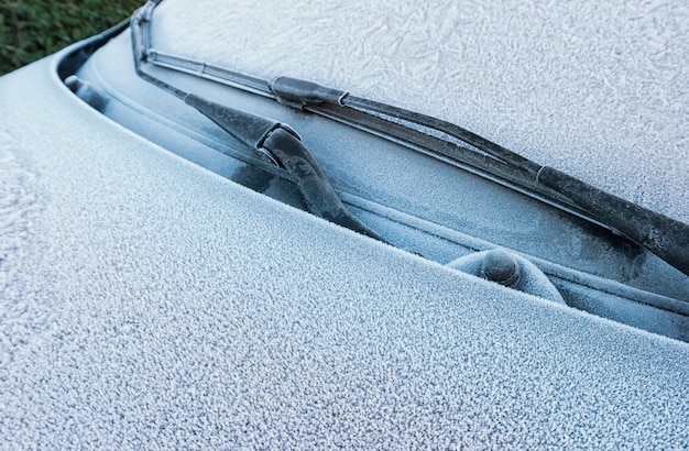 Parabrezza dell'auto coperto di ghiaccio e neve